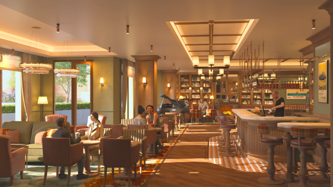 A warmly lit lounge bar with people sitting at tables and a bartender at the counter. There is a grand piano by the windows and bookshelves in the background.